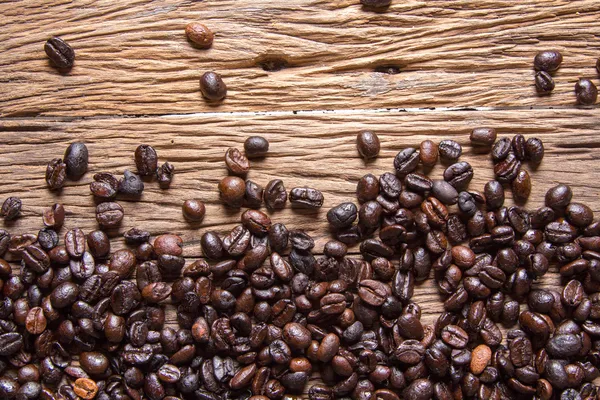 Grãos de café em fundo de madeira — Fotografia de Stock