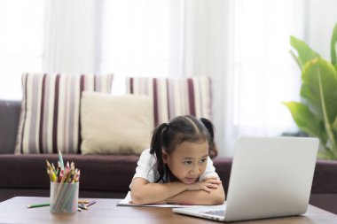 Asyalı kız ev ödevlerini online olarak çalışıyor evde ders veriyor, sosyal uzaklık online eğitim fikri