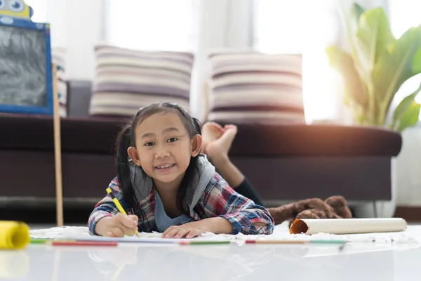 Счастливая Милая Девочка Рисует Цветными Ручками Лежа Полу Дома — стоковое фото