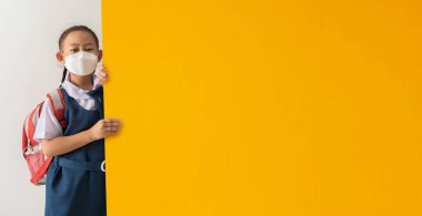 Asyalı liseli kız öğrenci, elinde sarı boş bir kağıt tutarak üniforma giyiyor ve şarkı söylüyor..