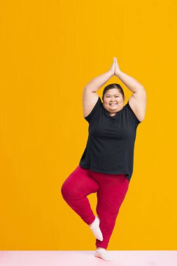 Asian fat woman workout isolated on yellow background, Clipping paths for design work empty free space
