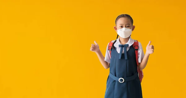 Asian Student Little Girl Wear Medical Face Mask Show Thumbs — Zdjęcie stockowe