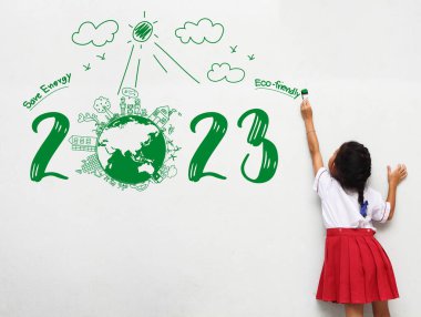 2023 Yeni Yıl Asyalı küçük kız elinde boya fırçası ile yaratıcı çevre ve çevre dostu tablolar yaparak duvar odası enerjisinden tasarruf ediyor.