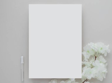 Beyaz davetiye modeli, bej arka planda beyaz bir çiçek, en az bej iş yeri kompozisyonu, düz yatış, model