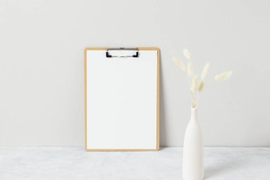 Ev dekorasyonu, masa üzerinde otlar, ön manzara, boş kağıt kartları, tebrik kartı Mockup. Beyaz arkaplanda vazodaki güzel beyaz pampalar