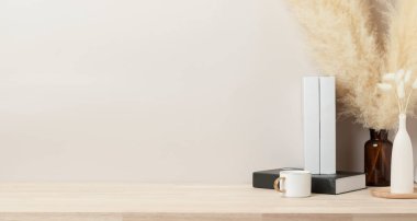 Kurumuş Bunny Tail ve pampa otlarıyla ev dekorasyonu, ön manzara, vazoda güzel pampa otları ve ahşap masada beyaz kitap ve bej beton arka plan.