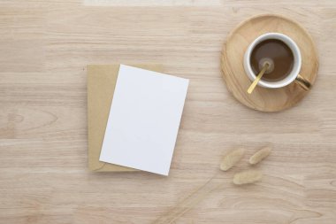 Boş kağıt kartlar, boş tebrik kartı davetiyesi kurutulmuş tavşancık kuyruğu çimeni ve kahve fincanı ahşap masa arkaplanı, asgari ahşap masa çalışma alanı kompozisyonu, düz yatak, maket