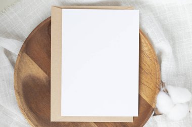 Boş kağıt kartlar, boş tebrik kartı davetiyesi, el işi zarflı maket, masa arkasında kurutulmuş tavşan kuyruğu çimeni, minimum masa çalışması kompozisyonu, düz yatak, model.