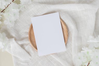 Boş kağıt kartlar, boş tebrik kartı davetiyesi masa arkaplanında çiçek olan Mockup, en az masa başı iş yeri kompozisyonu, düz yatak, maket