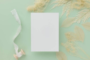 Boş tebrik kartı daveti Kahverengi zarf üzerinde Mockup 5x7 pastel yeşil arka plan, düz yatış, model