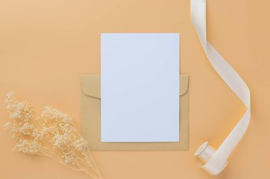 Boş tebrik kartı daveti Kuru çiçekli zarfa Mockup 5x7 Ve kağıt arka planda şerit, düz yatış, model