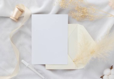 Boş tebrik kartı daveti Kuru çiçekli zarfa Mockup 5x7 Ve kağıt arka planda şerit, düz yatış, model