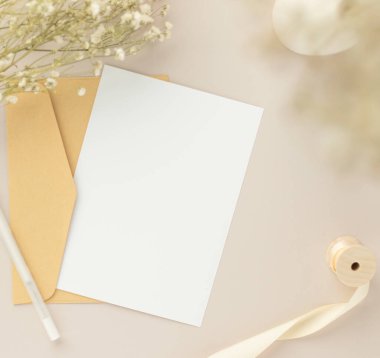 Boş tebrik kartı daveti Kuru çiçekli zarfa Mockup 5x7 Ve kağıt arka planda şerit, düz yatış, model