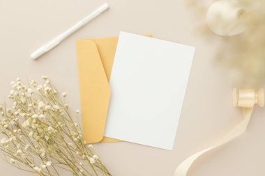Boş tebrik kartı daveti Kuru çiçekli zarfa Mockup 5x7 Ve kağıt arka planda şerit, düz yatış, model