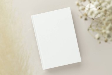 Beyaz kitap boş kapak, bej bir arka plan, kuru çiçek, düzlük, maket