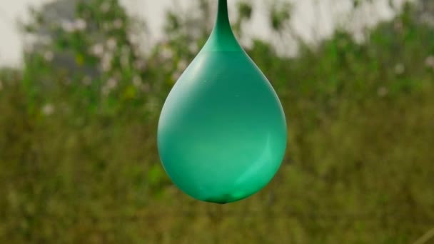 Opknoping Water Ballon Explosie Gepresenteerd Groene Natuurlijke Wazig Achtergrond Verbazingwekkende — Stockvideo