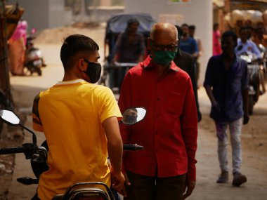 Two mask wearing people interchanging root path at city traffic covid timing at city Katni Madhya Pradesh in India on March 2022.