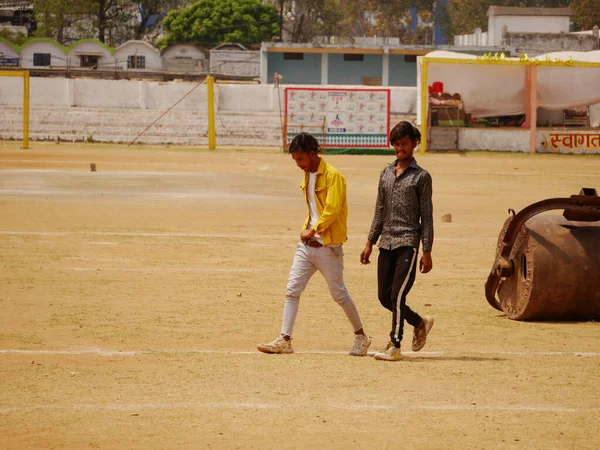 Hindistan 'ın Katni Madhya Pradesh şehrinde 2022 Mart' ında iki Hintli çocuk boş kriket sahasında birlikte yürüyorlar..