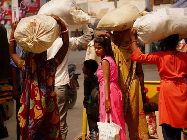 2022年3月にインドのカッニ マディヤ プラデーシュ州で昼間の交通渋滞の間に袋を運ぶインドの貧しい女性グループ — ストック写真
