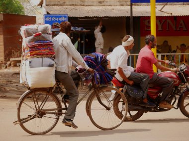 Mart 2022 'de Hindistan' da Katni Madhya Pradesh şehrinde bisiklet üzerinde kıyafet taşıyan sokak giysicisi..