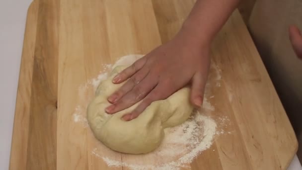 Mains de femme pétrissant pâte sur table en bois — Video