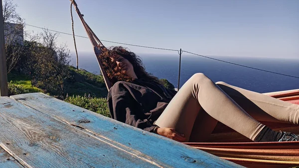girl relaxing in a hammock overlooking the ocean in a rural house on the island of La Palma, Canary Islands