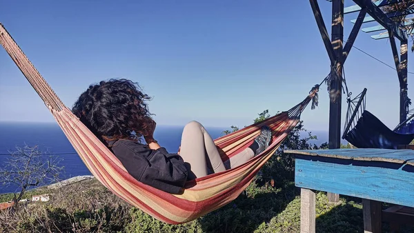 girl relaxing in a hammock overlooking the ocean in a rural house on the island of La Palma, Canary Islands