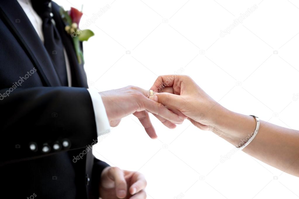 Newly married couple putting wedding ring on the finger