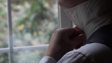 Bir adam boynuna papyon takar.