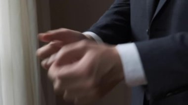Erkek işadamı kollardaki kelepçeleri düzeltir.
