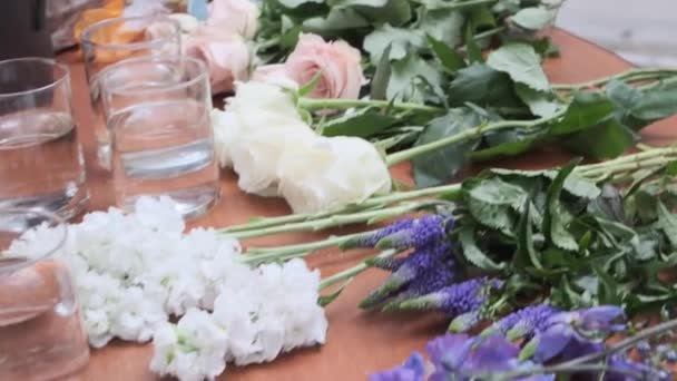 装飾者のテーブルの上の花は山の中に並べられ — ストック動画