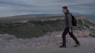 Bir turist dağ boyunca yürür.