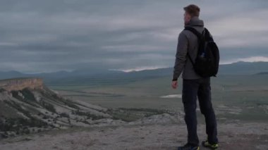 Bir turist dağ boyunca yürür.