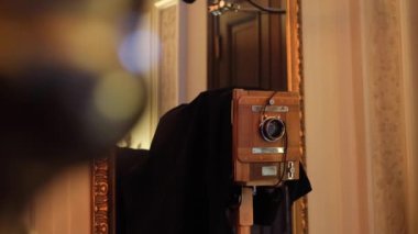  Klasik kamera ahşap. Adam dikkatle eski fotoğraf makinesine bakıyor, lensleri ayarlıyor, ahşap kameraya bakıyor. .