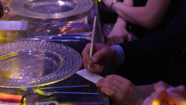 Yemek Masasında Bir Adam Küçük Bir Kağıt Parçasına Yazar — Stok video