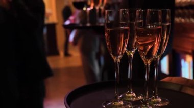  Garson elinde alkol bardakları tutuyor.