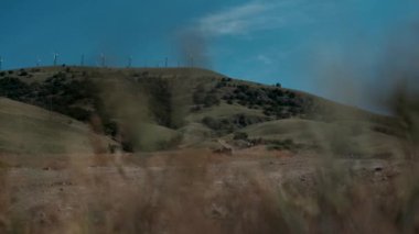 Güneşli bir günde mavi gökyüzü ve beyaz bulutlarla yakın çekim rüzgar türbinleri veya rüzgar enerjisi dönüştürücüsü