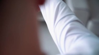  İş adamı giyiniyor. Beyaz gömlekli şık bir iş adamı kravatını düzeltiyor ve ceketini ilikliyor. Kapat