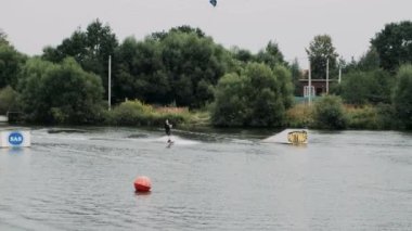  Nehirdeki bir teknenin arkasında sörf tahtasında