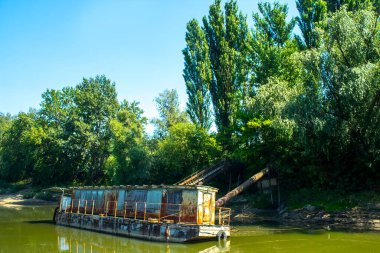 Nehirdeki iskelede eski paslı bir mavna