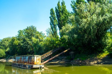 Nehirdeki iskelede eski paslı bir mavna