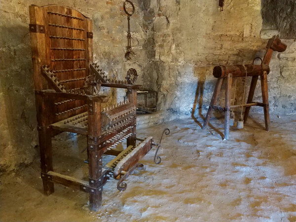 Wooden chair of torture displayed in chamber of a castle