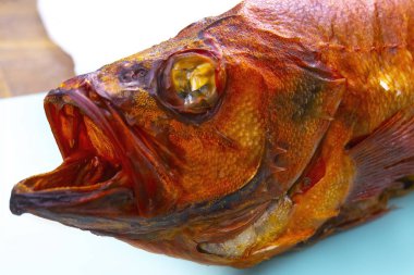 Beyaz arka planda izole edilmiş sıcak füme levrek balığı..