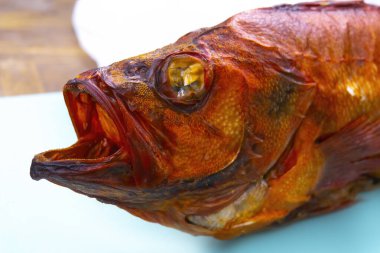 Beyaz arka planda izole edilmiş sıcak füme levrek balığı..