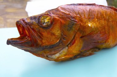 Beyaz arka planda izole edilmiş sıcak füme levrek balığı..