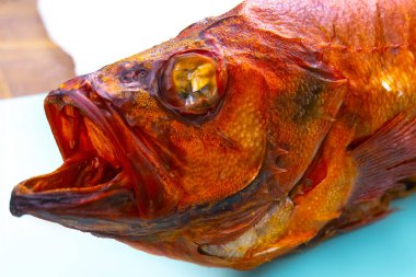 Beyaz arka planda izole edilmiş sıcak füme levrek balığı..