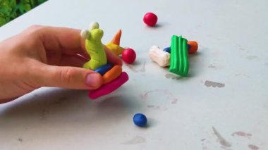 Masadaki plastik maddeden çocuk kalıpları. Çocuklar renkli plastik ellerle, çocuklar eğitici oyuncaklarla.