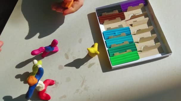 テーブルの上のプラスチックから子供の型 子供の手に色のプラスチック 子供の教育用おもちゃ — ストック動画