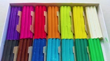 Beyaz arka planda izole edilmiş renkli plastik çubuklar. Çocuklar için gökkuşağı modelleme kil oyunu ve yaratıcılık.