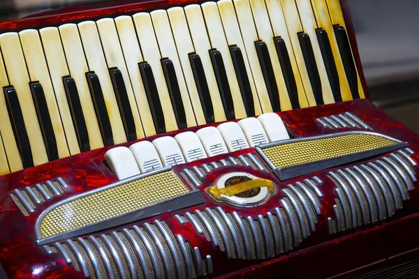 The old rare red accordion . Buttons and keyboard close up view.